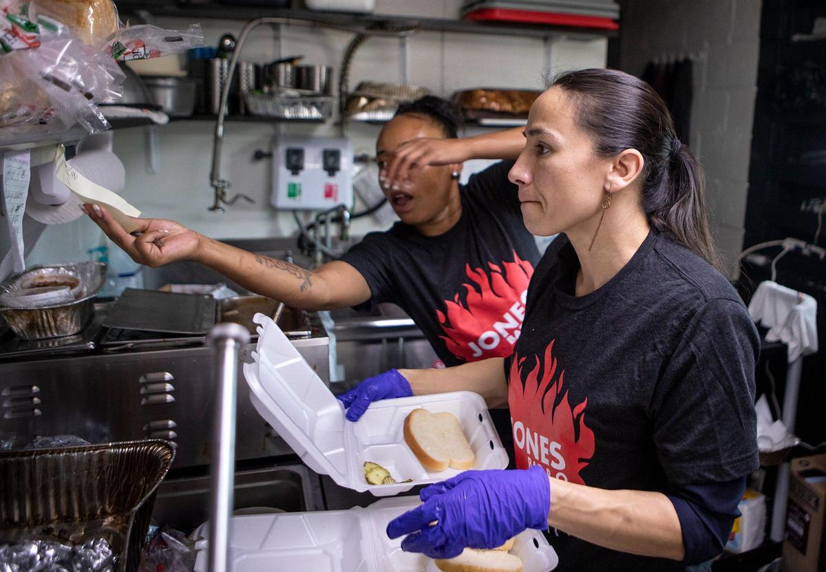 Earlier this year, Kansas Rep. Sharice Davids prepared meals at Jones Bar-B-Q as Juanda Henderson reached for an order. Davids works to connect with local businesses through her “Sharice’s Shift” program