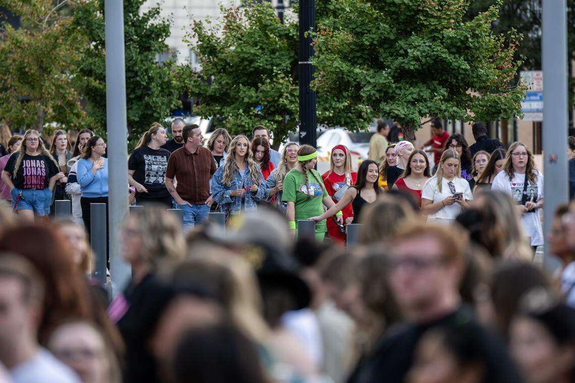 People stand in line outside T-Mobile Center to attend the Jonas 20: Greetings from Your Hometown tour on Tuesday, Oct. 7, 2025, in Kansas City.