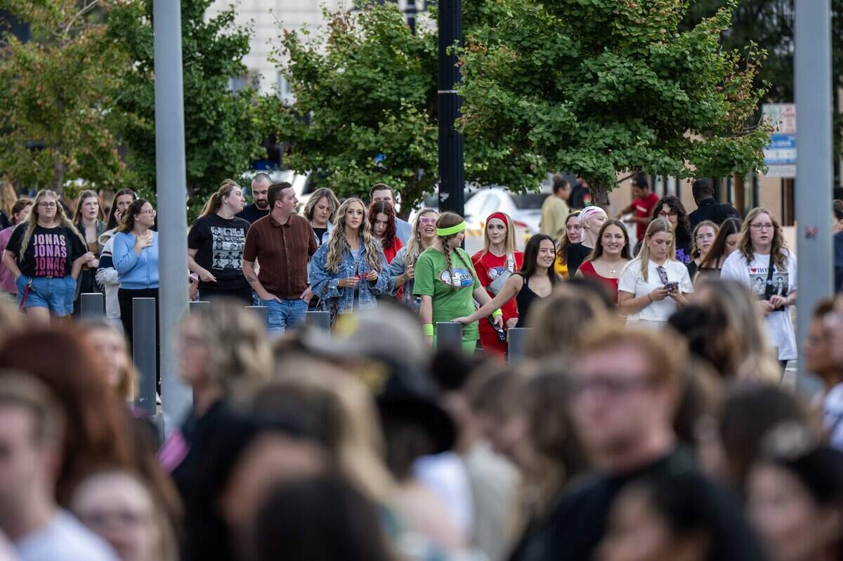 People stand in line outside T-Mobile Center to attend the Jonas 20: Greetings from Your Hometown tour on Tuesday, Oct. 7, 2025, in Kansas City.