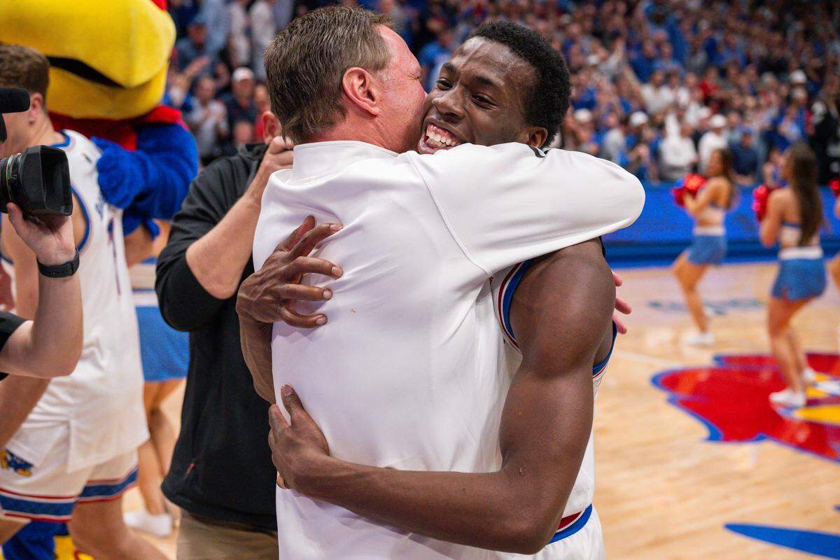 Kansas Jayhawks guard Melvin Council Jr. (14) hugs head coach Bill Self on the court following the win vs. the Arizona Wildcats on Monday, February 9, 2026, at Allen Fieldhouse.