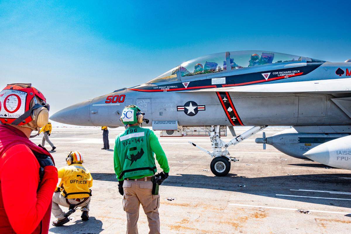 Crew members prepare to catapult a fighter jet from the USS Harry S. Truman aircraft carrier.