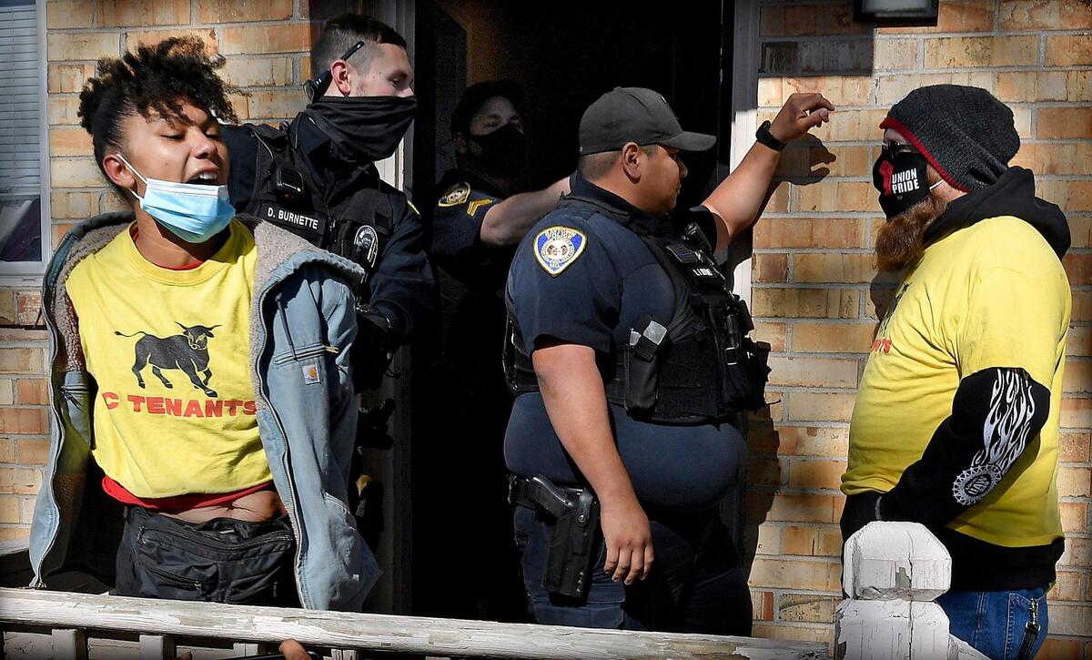 While Raytown Police entered an apartment to execute an eviction Monday afternoon, Jenay Manley, left, and Gary Thomas, right, both members of the organization, KC Tenants, formed part of a human blockade to try and stop the process that they felt was unlawful. About fifteen members of the group shouted “all evictions are an act of violence,’’ as officers removed a woman who lives at the El Dorado Apartments in Raytown.