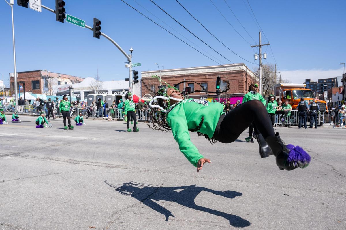 A dancer for the Kansas City Marching Wildcats drill team does a midair maneuver during the Kansas City St. Patrick’s Day Parade on Monday, Mar. 17, 2025.