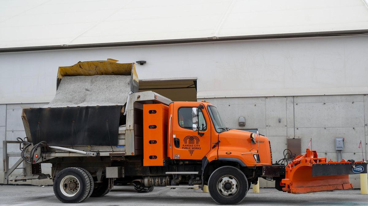 A snowplow driver waits as a front-end loader fills his truck with salt at the Kansas City Public Works Department on Saturday, Jan. 4, 2024. The city is ready for one of its biggest winter storms in years, with 40,000 tons of salt, 8,000 tons of IceBan, 36,000 gallons of calcium chloride, 300 snowplows, and 400 drivers.