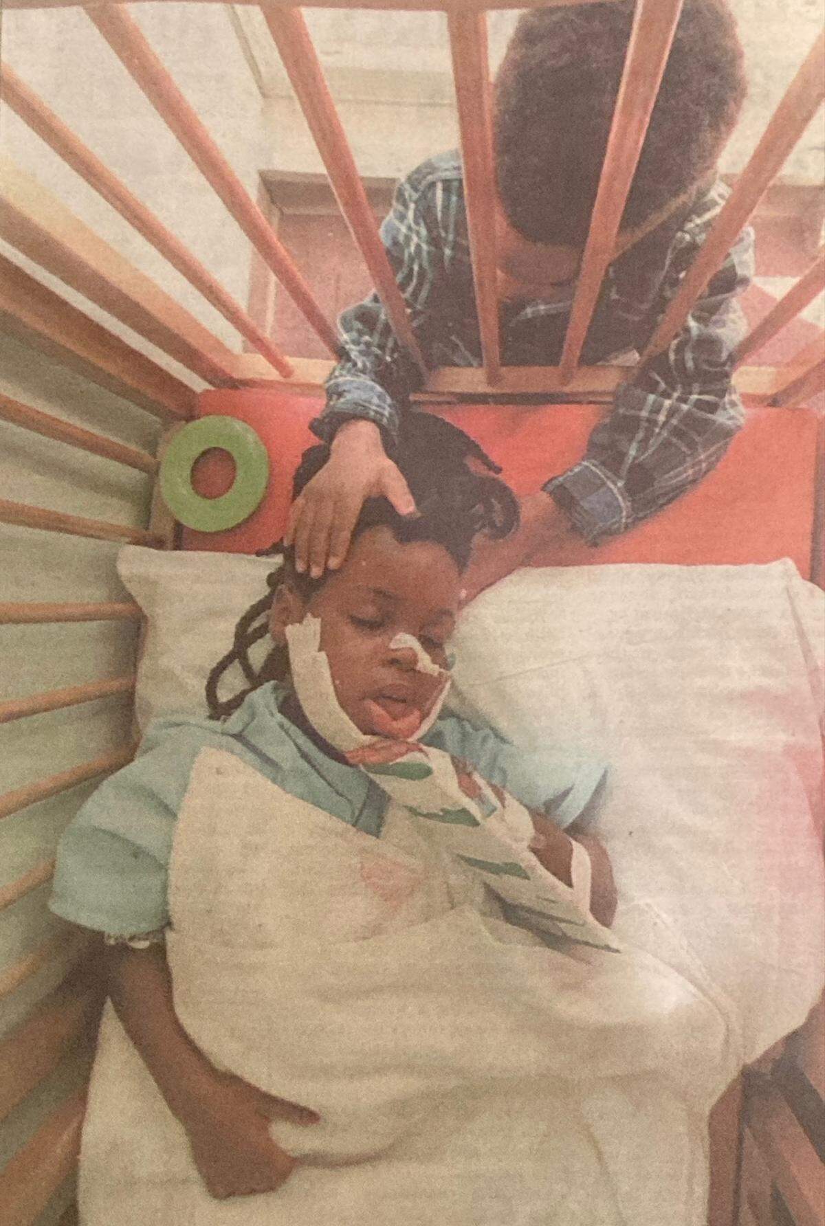 Tashay Campbell, 6, being comforted at Children’s Mercy Hospital by her brother, T.T., after she was treated for a gunshot wound to the face 30 years ago.