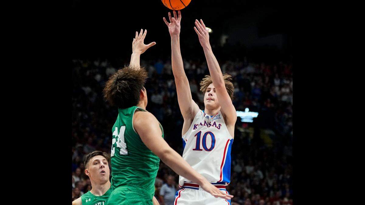 Kansas Jayhawks guard Johnny Furphy shoots against Manhattan’s Xinyi Li (No. 24) and Brett Rumpel (No. 4) during Friday night’s game at Allen Fieldhouse.