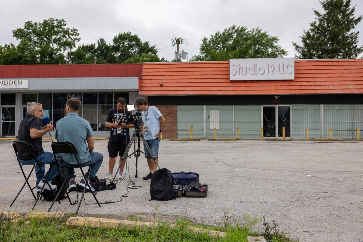 Argentinian sports journalists Joaquin Bruno, left and Agustin Fantasia, along with producer Matias Errecalde and camera man Fernando Lopez with TyC Sports sit outside Studio 12 LLC to report on the mass shooting the occurred early Saturday morning on Troost Avenue on Monday, June 8, 2026, in Kansas City, Missouri. The shooting, which injured nine adults, drew coverage from international media in the city ahead of the 2026 FIFA World Cup.