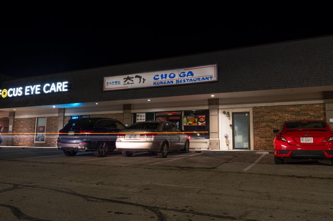 Car lights blur as Choga closes for the night in Overland Park. “I think that’s what Choga is, it’s now a symbol of togetherness of our Korean community,” manager Daniel Chuang said.