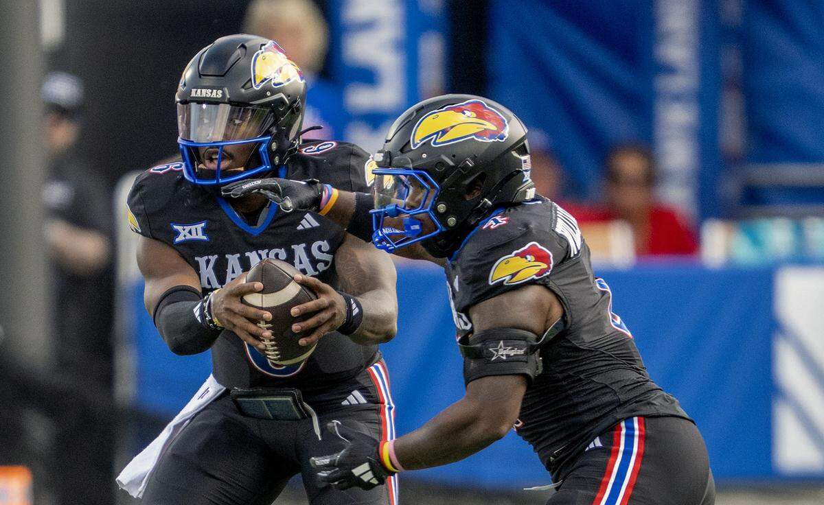 Kansas Jayhawks quarterback Jalon Daniels (6) hands off to running back Leshon Williams (4) in the first half of the game against the West Virginia Mountaineers at David Booth Kansas Memorial Stadium on Saturday, Sept. 20, 2025, in Lawrence.