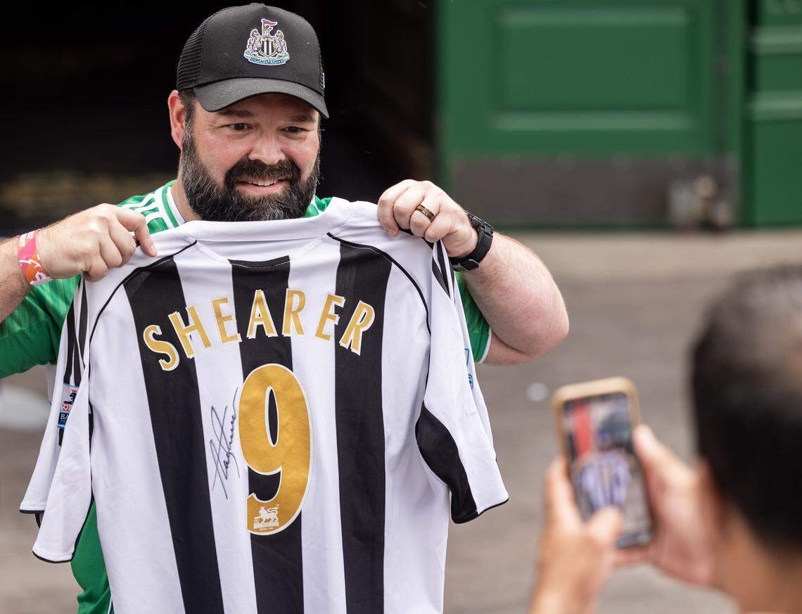 Tony Egizi, of St. Louis, poses for a picture after former English Premier League player and TV commentator Alan Shearer signed his jersey in Kansas City’s Power & Light District on Saturday, Sept. 20.