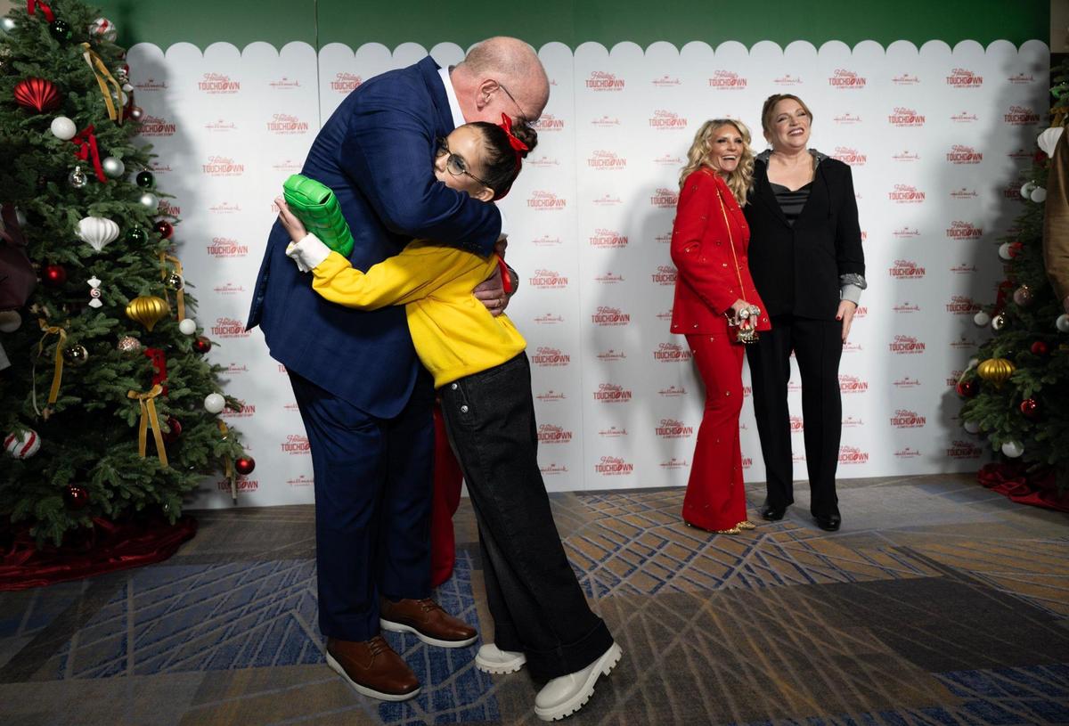 Chiefs Head Coach Andy Reid hugs Taylen Biggs, a social media personality, at Hallmark’s Premiere screening of the movie “Holiday Touchdown: A Chief’s Love Story” on November 30, 2024, in Kansas City.