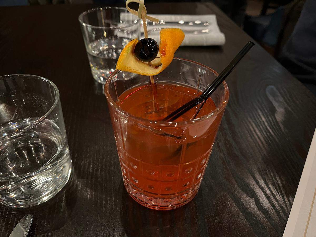 Prima Facie’s mezcal old fashioned is made with mezcal, tequila, simple, cranberry juice, orange bitters, luxardo cherry and an orange peel.
