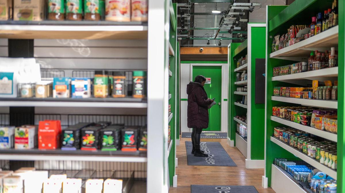 A shopper looks through the personal hygiene care aisle during the grand opening of Community Groceries. The store is also home to various local products.