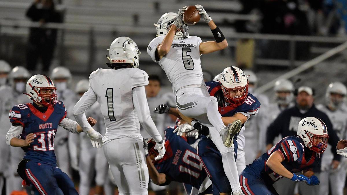 Blue Valley North’s Ian Loftus leaps into the air to recover an Olathe North onside kick during the fourth quarter of Friday night’s Kansas Class 6A semifinals game at the Olathe District Athletic Center (Nov. 20, 2020).