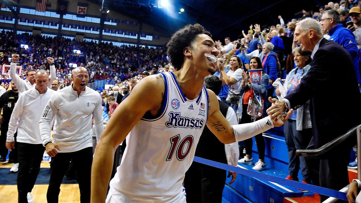 KU’s Jalen Wilson and the Kansas coaching staff celebrate with the Jayhawk faithful after KU beat Iowa State 62-60 at Allen Fieldhouse on Jan. 14, 2023.