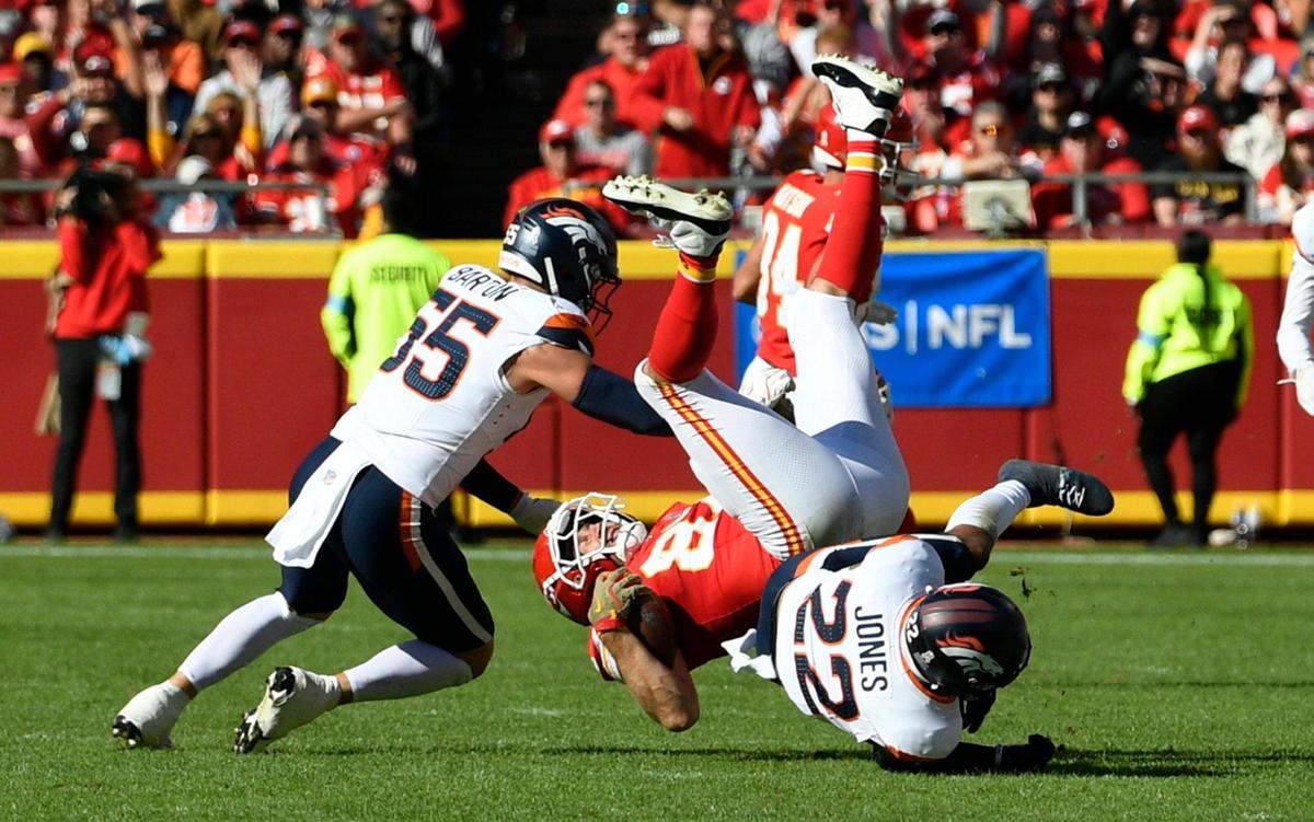 Kansas City Chiefs tight end Travis Kelce (87) is upended by Denver Broncos fullback Michael Burton (20) in the first half on Sunday, Nov. 10, 2024, at GEHA Field at Arrowhead Stadium.