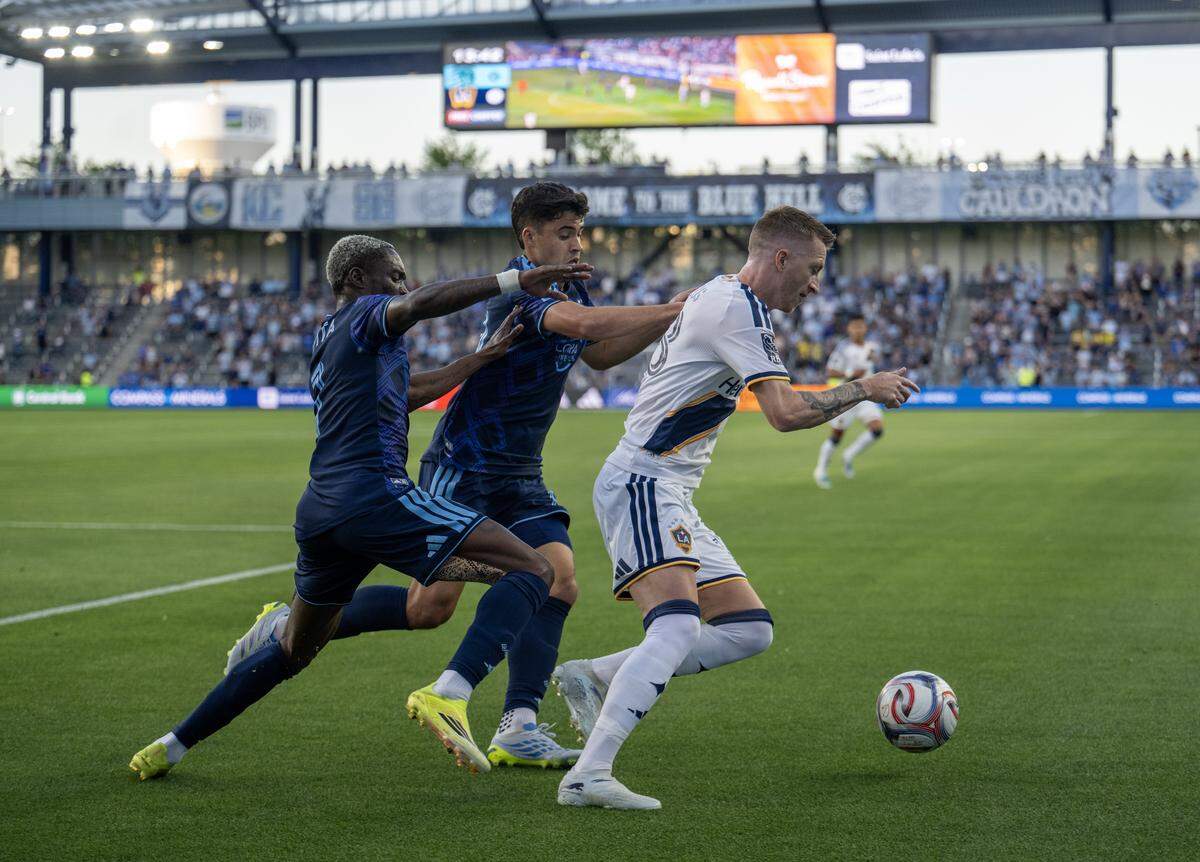 Sporting Kansas City forward Capita Capemba (7) and Sporting Kansas City forward Dejan Joveljic (9) go up against LA Galaxy midfielder Marco Reus (18) in the first half at Sporting Park on Wednesday, May 13, 2026, 2026, in Kansas City, Kansas,