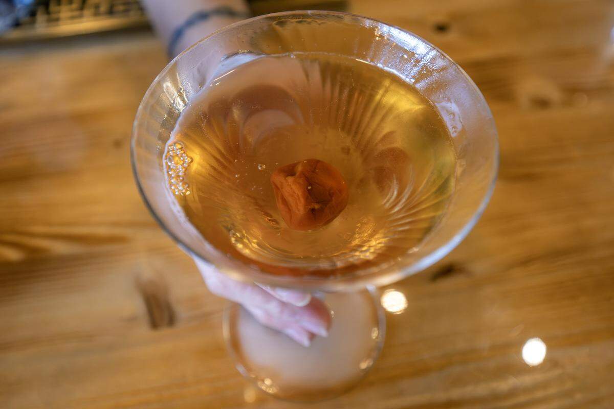 A cocktail served martini-style and garnished with a plum is seen at Moon Bar KC on Tuesday, Dec. 16, 2025, in Kansas City.