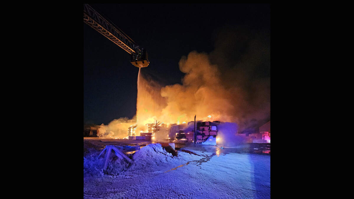 Firefighters used aerial trucks to stream water down upon stacks of burning lumber early Monday at the Central Missouri Reload Inc. lumberyard, 3900 E. 14th Terrace.