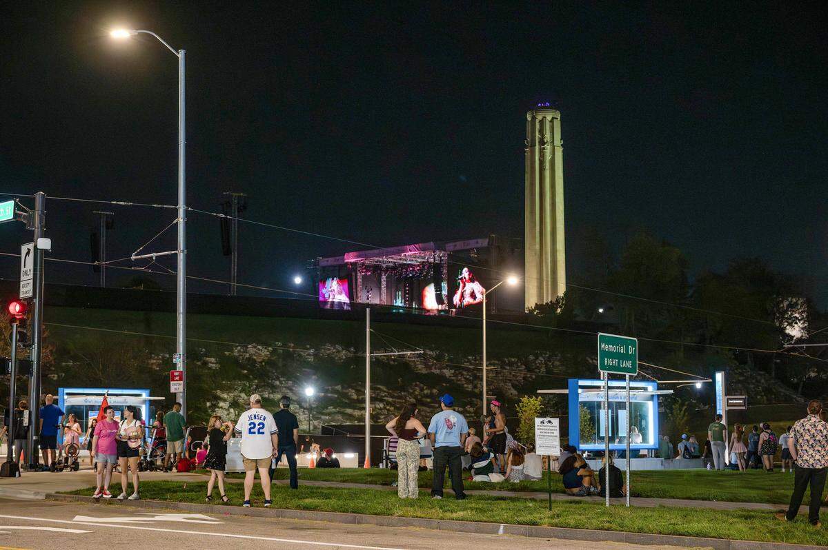 People watch pop singer Chappell Roan perform from Main Street outside the National WWI Museum and Memorial during her Visions of Damsels and Other Dangerous Things tour stop on Friday, Oct. 3, 2025, in Kansas City.