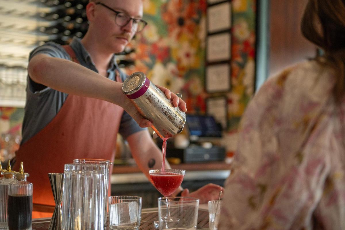 Zach Nielsen, a bartender, pours a cocktail at Wild Child’s invite-only soft opening on Thursday.