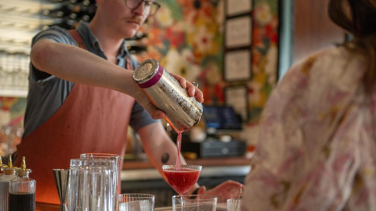 Zach Nielsen, a bartender, pours a cocktail at Wild Child’s invite-only soft opening on Thursday.