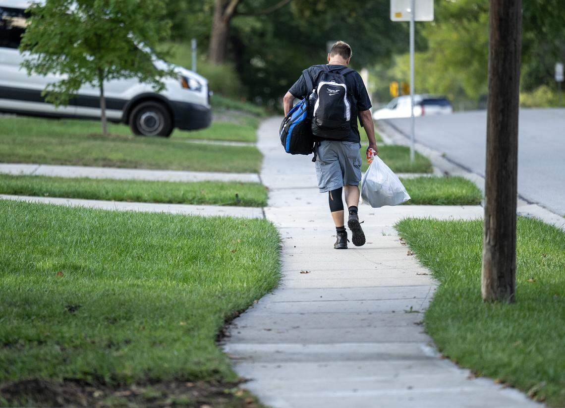 After eating a free hot meal and “shopping” at the clothing closet at Center of Grace, a outreach center, Thomas West, unhoused since April, walked with his belongings along Harrison Street in Olathe on Wednesday, Sept. 24, 2025. West has stayed at Project 1020 during winters and receives some support from Johnson County Mental Health, though he acknowledges their resources are limited. The cause of his homelessness was primarily legal and logistical issues that led to losing his home, car, and family, causing a “ripple effect.”