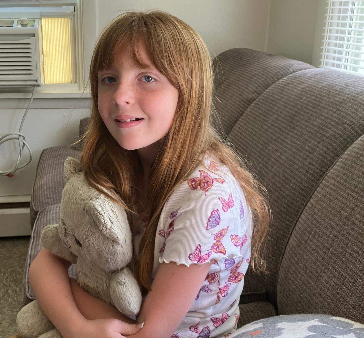 Kyla Tangen, whose mother, Jessica, died at a Chiefs training camp practice this summer, clutches a special teddy bear.