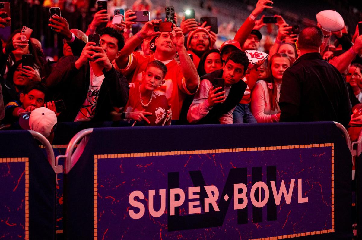 Football fans try to capture images of Kansas City Chiefs players as they enter Allegiant Stadium during Super Bowl LVIII’s Opening Night event on Monday, Feb. 5, 2024, in Las Vegas.