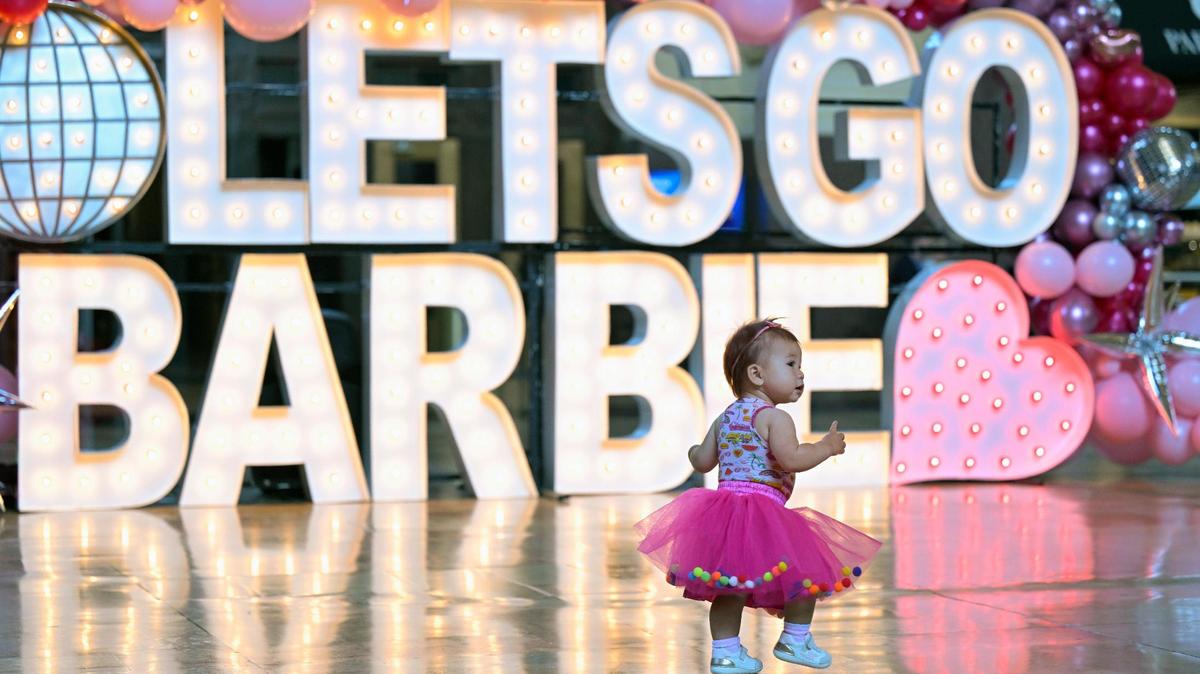 Eleven-month-old Scarlett Osburn accompanied her mother, Grace Osburn of Kansas City to Union Station for Barbie-themed photos on Thursday. Barbie fans flocked to the station for photos with a life-size Barbie box, an Alpha-Lit display and vintage Barbie artifacts. Barbie, the movie, opens Friday at Union Station’s Regnier Extreme Screen Theatre.