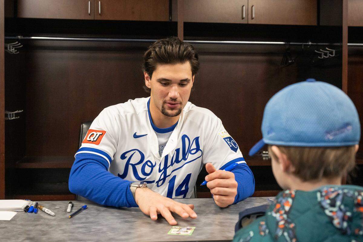 Kansas City Royals outfielder Jac Caglianone signs a baseball card for a young fan during Royals Rally at Kauffman Stadium on Saturday, January 31, 2026.