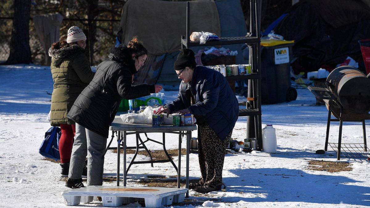 As winter settles in across the region, donations of food and clothing become even more important in the day to day lives of the homeless. At this encampment on the northeast side of downtown Kansas City, BaTino Alao, from left, Mary Lawrence and Theresa Sweet, sort through some of the food that had been dropped off earlier in the day. All three are residents there.