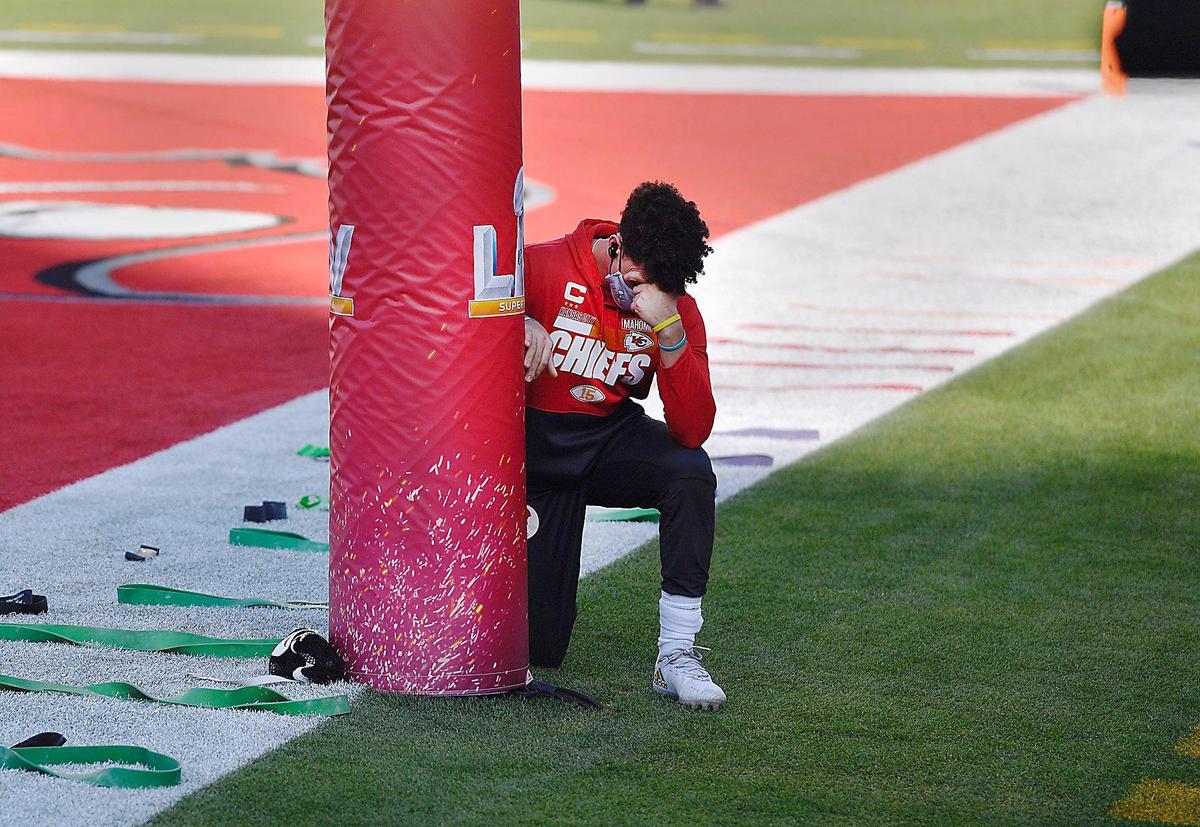 Kansas City Chiefs quarterback Patrick Mahomes kneels in prayer next to the goalpost Sunday, February 7, 2021, before Super Bowl LV at Raymond James Stadium in Tampa, Florida.