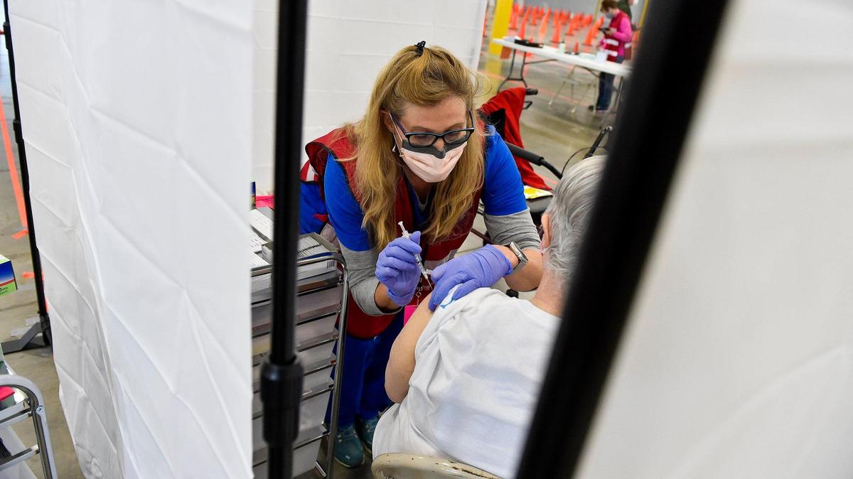 Platte County Health Department nurse Karla Hunt gives Phyllis McCaslin of Kansas City, 73, a vaccine dose. Several three-sided booths were set up for privacy. The Platte County Health Department opened a mass vaccination clinic in an unused warehouse in the Horizons Industrial Park in Riverside Tuesday, Mar. 2, 2021. The space was donated by NorthPoint Development.