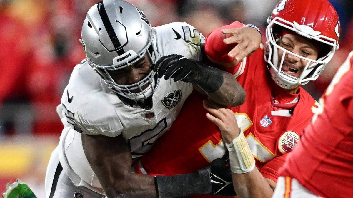 Kansas City Chiefs quarterback Patrick Mahomes (15) is hit by Las Vegas Raiders linebacker Divine Deablo (5) after throwing a pass in the second half on Friday, Nov. 29, 2024, at GEHA Field at Arrowhead Stadium.