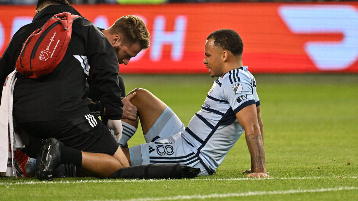 Sporting Kansas City defender Logan Ndenbe is examined by trainers during the second half of Sunday’s match against the St. Louis City SC at Children’s Mercy Park.