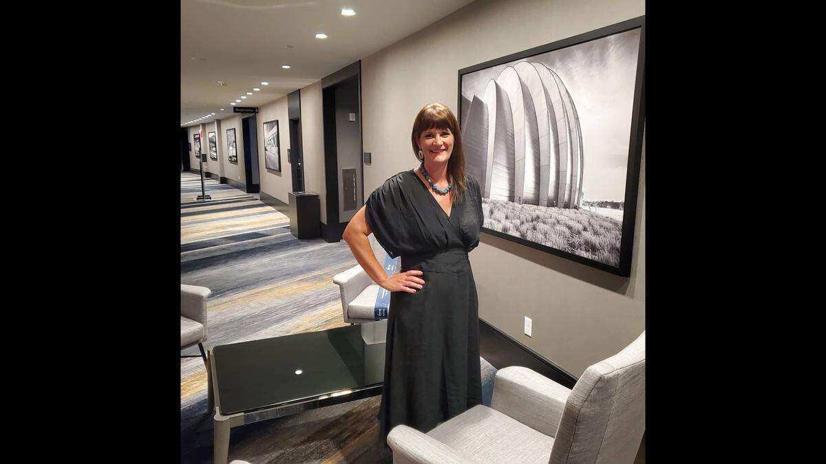 Kansas City artist Beth Houts stands in front of her pieces in this photo. She was a featured artist at the East of Oak Art Fest, but had to attend the festival without much of her artwork after her work was allegedly stolen from her home.