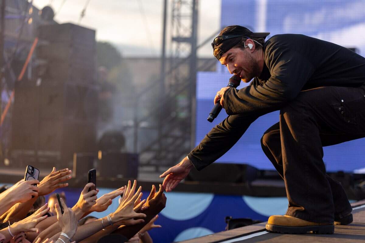 Andrew Taggart reaches out to hold crowd members hands during the FIFA Fan Fest Chainsmokers concert at Fan Fest on Sunday, June 21, 2026.