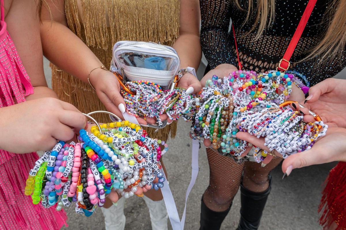 Taylor Swift fans showcase their friendship bracelets while waiting in line at Taylor Swift’s Eras Tour stop at GEHA Field at Arrowhead Stadium on Friday, July 7, 2023, in Kansas City.