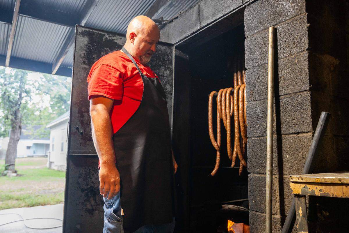 Mike Loges, owner of Peter May's House of Kielbasa, checks on sausages inside a smoker, on Tuesday, Oct. 7, 2025. The hole-in-a-wall restaurant has been around since the 1940s and used to be a neighborhood grocery store.