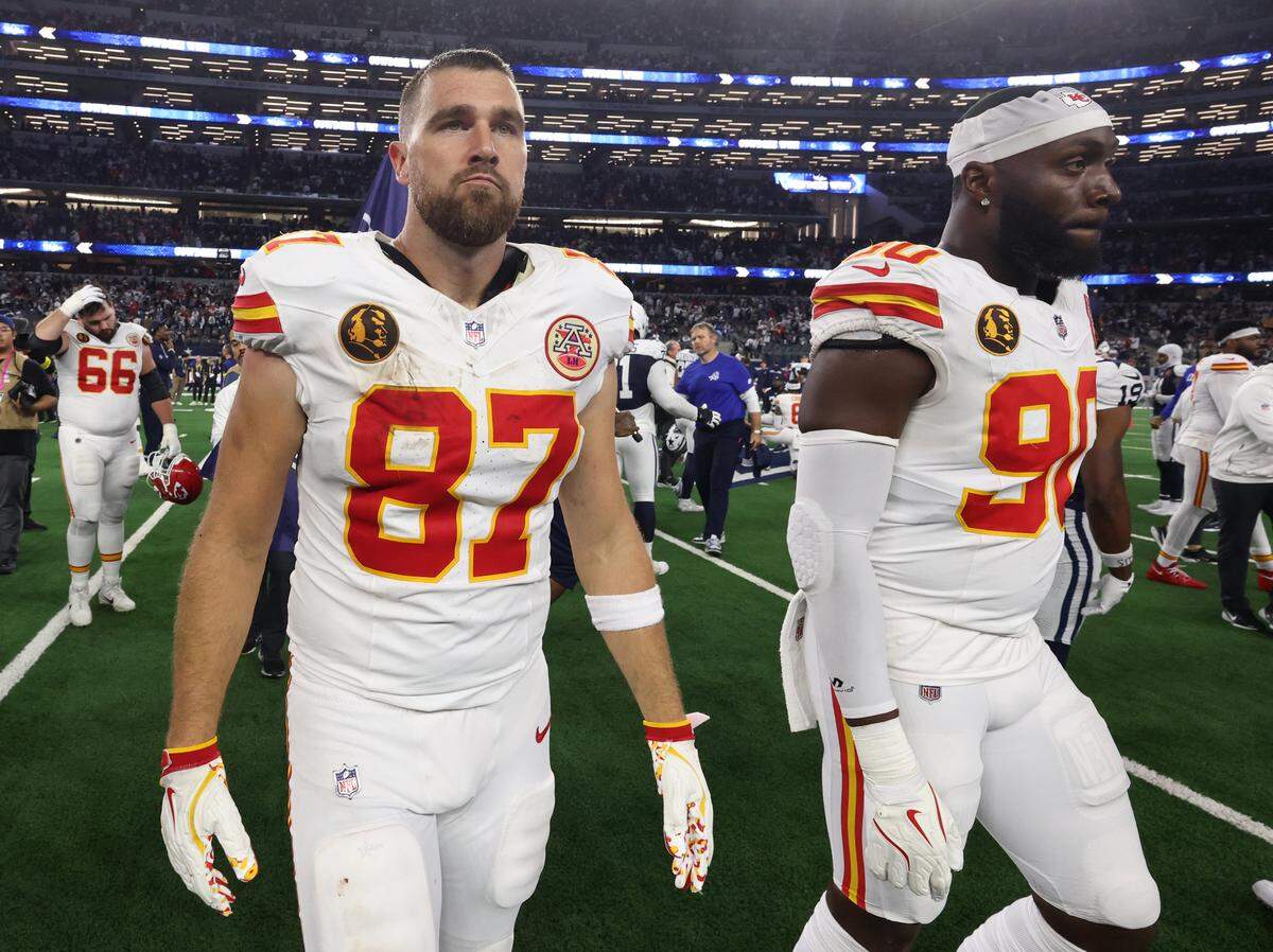 Kansas City Chiefs players Travis Kelce (No. 87) and Charles Omenihu (No. 90) walk off the field after the Dallas Cowboys’ 31-28 Thanksgiving Day victory in a Week 13 NFL game at AT&T Stadium in Arlington, Texas on Thursday, Nov. 27, 2025.