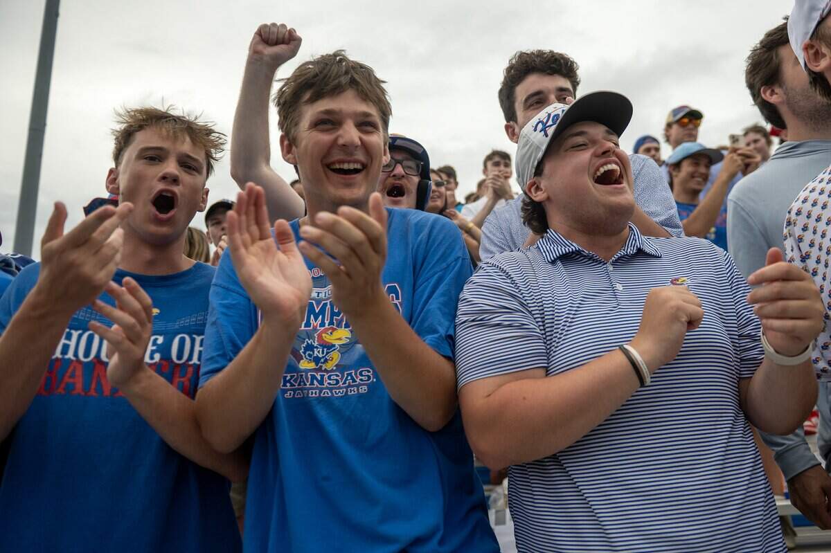 Colin Benick, left, Cooper Reeves and Jackson Harmon cheer during the Hot Dog Run between innings of an NCAA Tournament baseball game between Kansas and Oklahoma at Hoglund Ballpark on Saturday, June 6, 2026, in Lawrence.