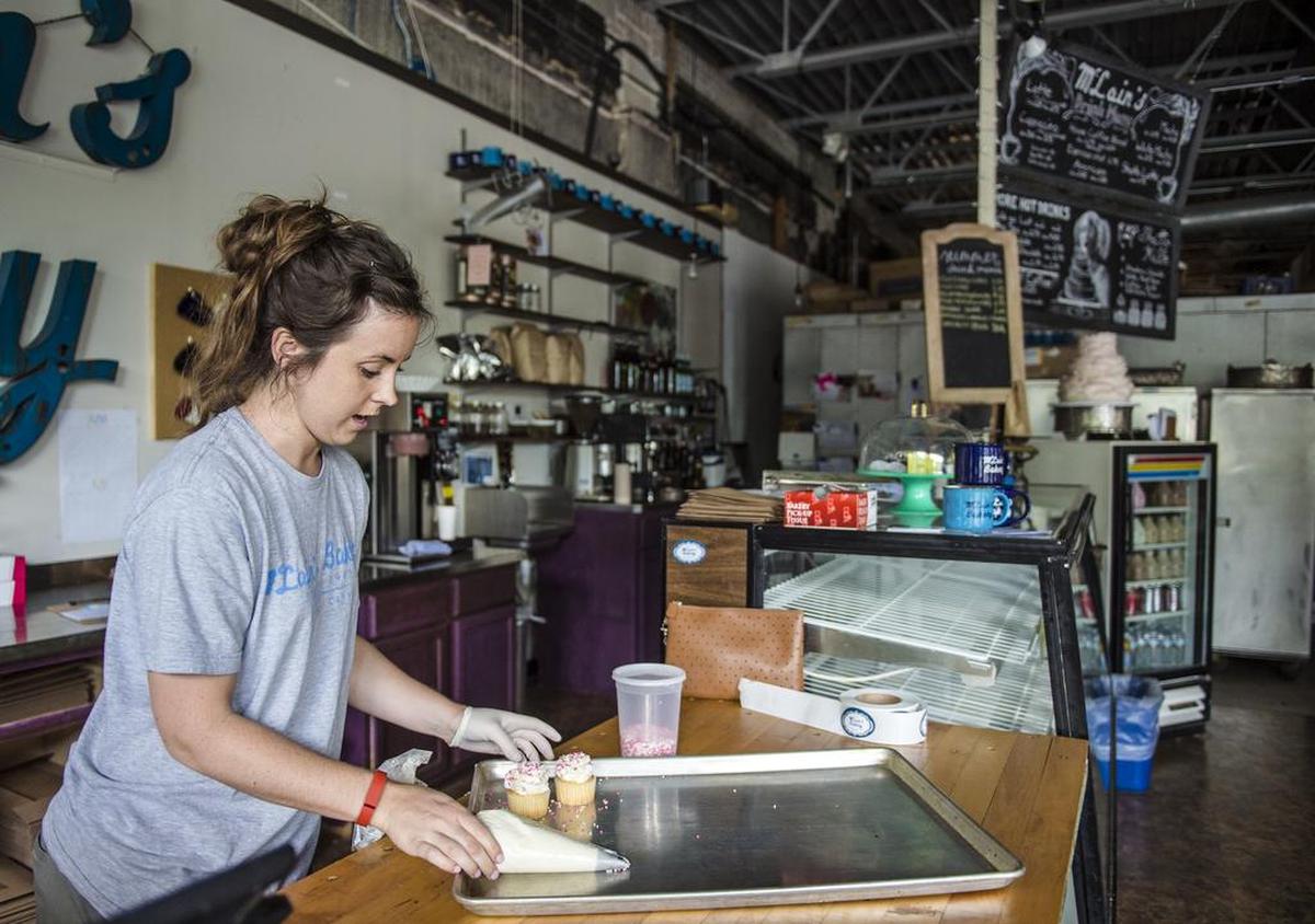 Mollie Lothman, co-owner of McLain’s Bakery, decorates cupcakes at the location at 201 E. Gregory Blvd.