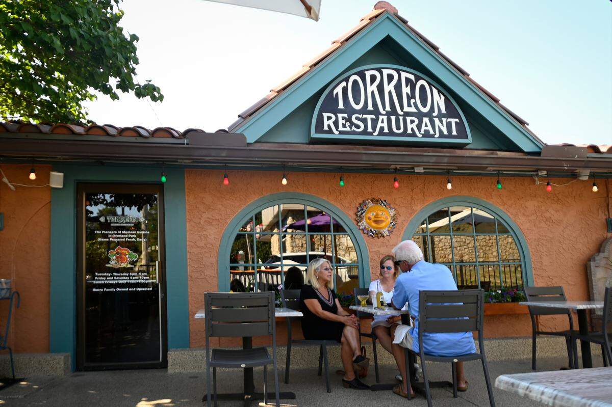 Denice Ibarra Hamilton, left, owner of Torreon Mexican Restaurant in Overland Park, talks with longtime customers Jo and Pat Kellerman on the patio.