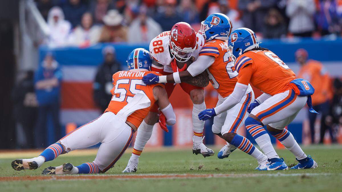 Jan 5, 2025; Denver, Colorado, USA; Kansas City Chiefs tight end Peyton Hendershot (88) is tackled by Denver Broncos linebacker Cody Barton (55) and cornerback Ja’Quan McMillian (29) and safety P.J. Locke (6) in the first quarter at Empower Field at Mile High. Mandatory Credit: Isaiah J. Downing-Imagn Images