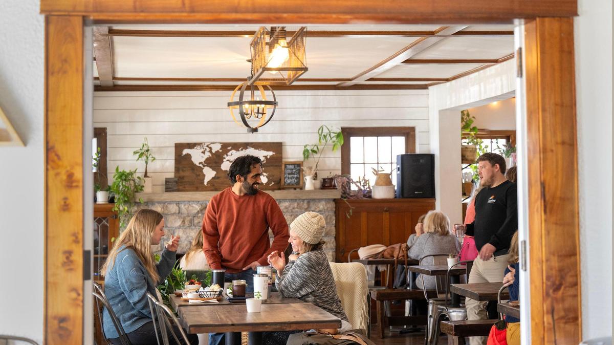 Caden Stucky, center, talks with customers at Cause Coffee, a De Soto coffee shop that donates its proceeds to nonprofits.