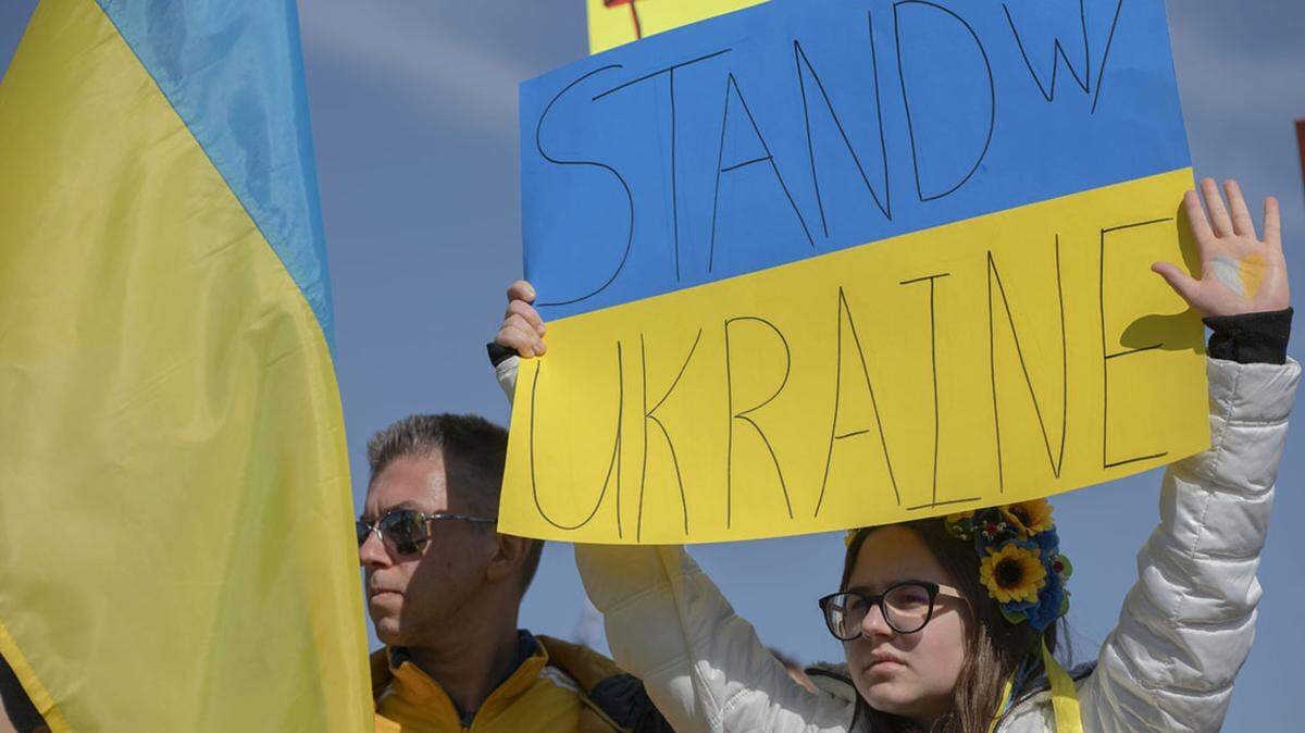 Demonstrators hold signs to show solidarity with Ukraine in response to the recent military invasion by Russia.