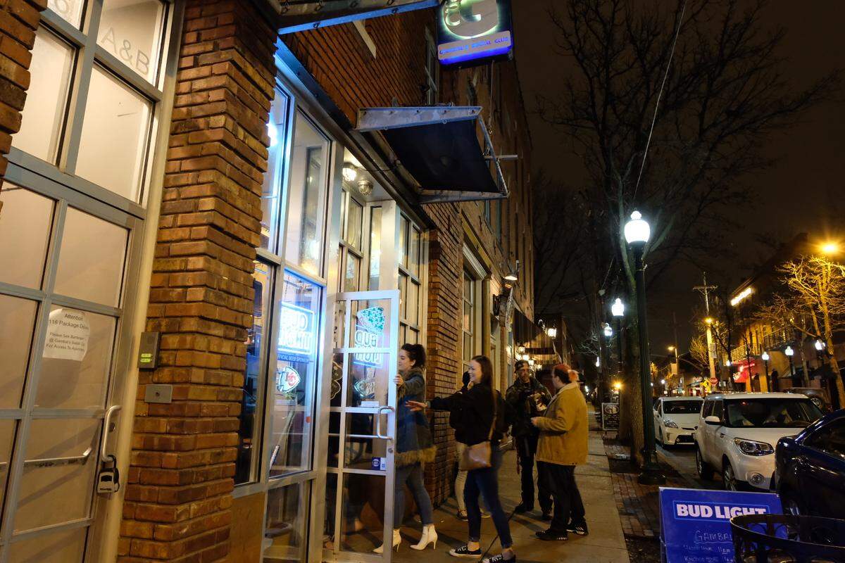 A group walks into Gambal’s Social Club Monday night, just a couple hours before a ban on gatherings of more than 10 people goes into effect.
