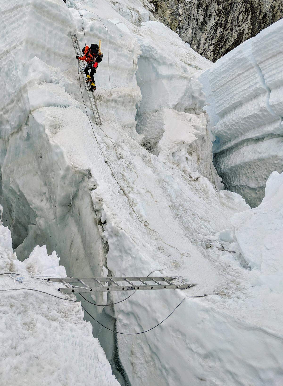 Elsa Bleeker, one of Becker’s climbing partners, ascends a ladder in the Khumbu Icefall.