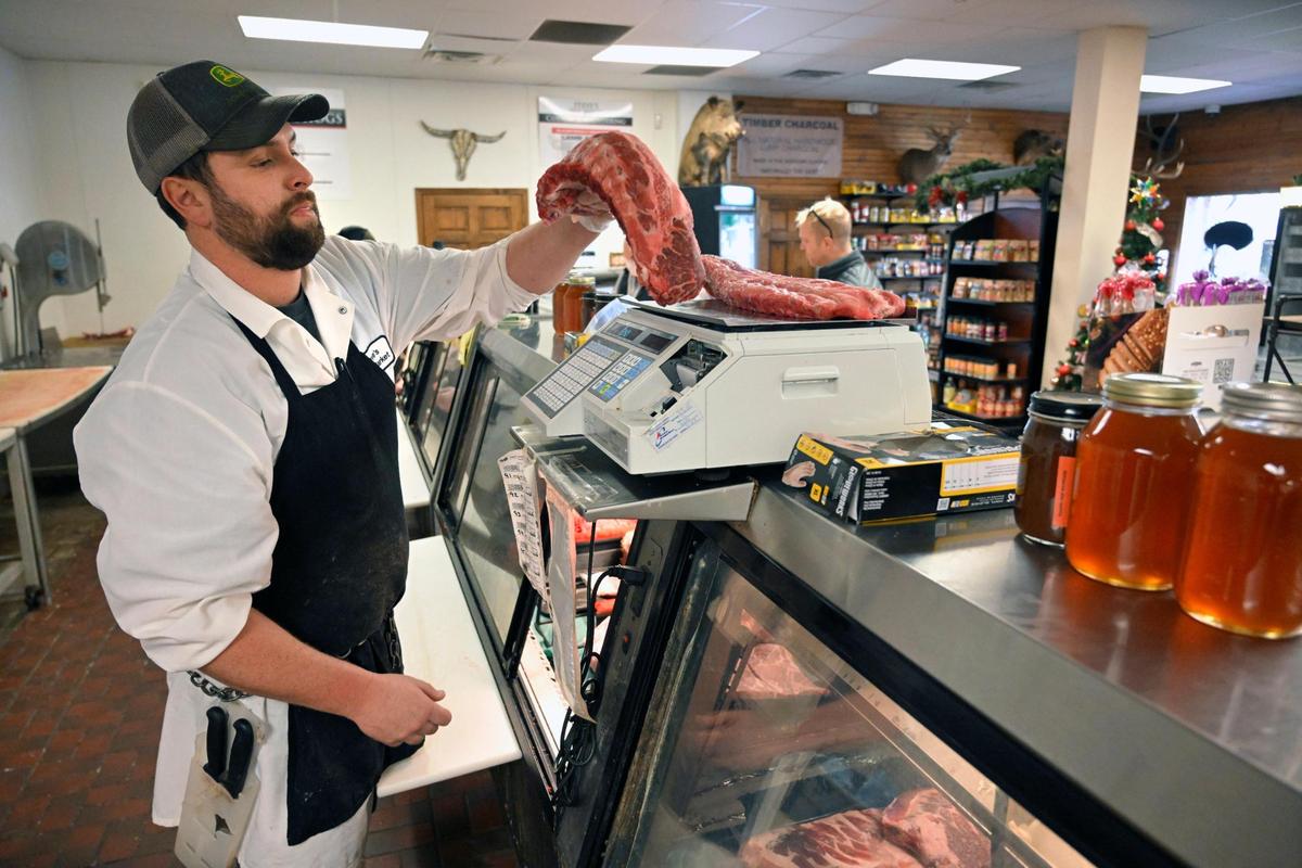 Stephen Prudden III, pulls ribs off the scale after weighing them for a customer on Dec. 28, at Steve’s Meat Market in De Soto, Kansas. Prudden III works with his father in the butcher shop which opened in 1969.